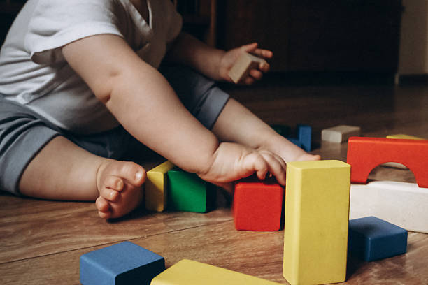 istock Baby Playing with Colorful Wooden Blocks on Floor 2252425274