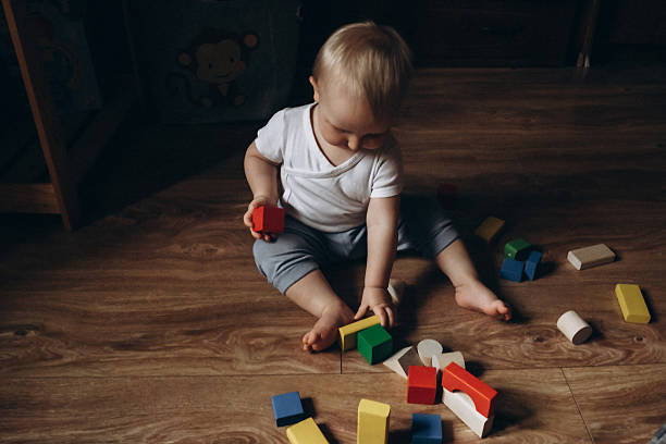 istock Baby Playing with Colorful Wooden Blocks on Floor 2252425335