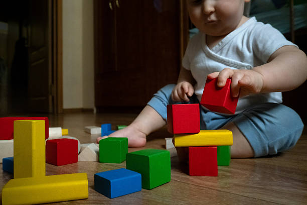istock Baby Stacking Colorful Blocks on Wooden Floor 2252425366