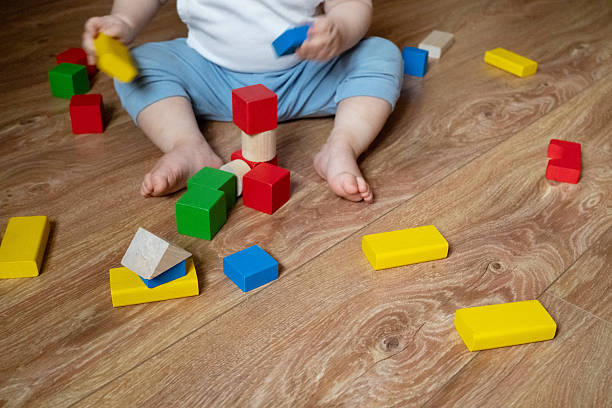 istock Young child focused on stacking multicolored wooden blocks, enhancing motor skills and coordination. The scene highlights early educational play and cognitive growth. 2252425490