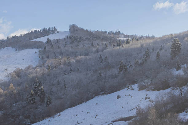 Mountainous terrain against a blue sky, there is some snow