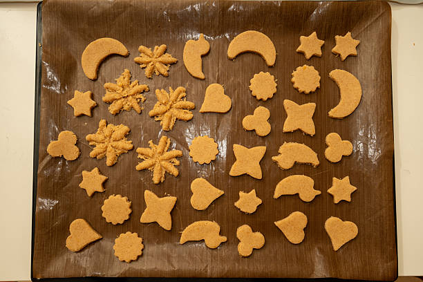 istock Overhead view of a baking tray lined with reusable parchment, filled with various shapes of raw cookie dough ready to bake 2252430646