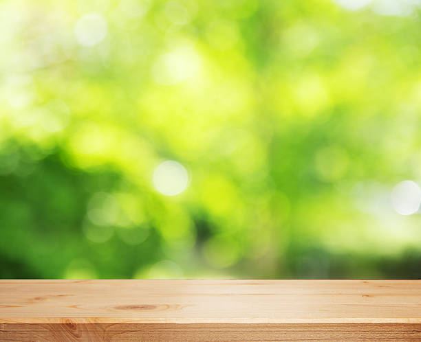istock Green natural bokeh. Beautiful spring summer defocused background with wooden empty table. Copy space. 2252431222