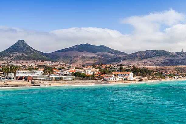 istock A sunny coastal town sits along a bright turquoise bay, framed by rugged hills 2252431349