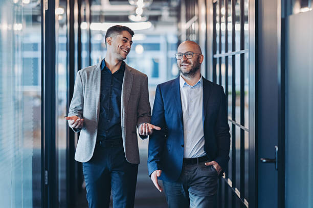 istock Smiling businessmen talking in the corridor 2252434604
