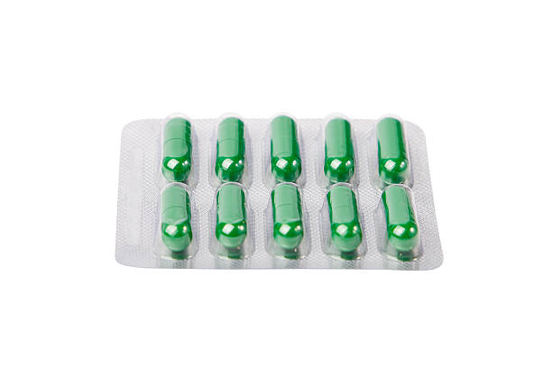 istock Green pills in blister pack isolated on white background. Clipping path 2252435783
