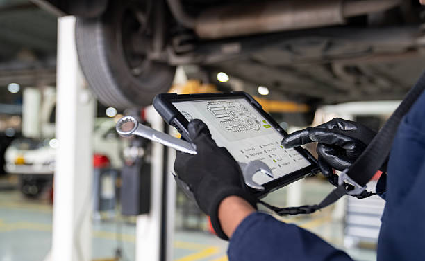 istock Mechanic holding a digital tablet while scanning a car for diagnosis 2252437454