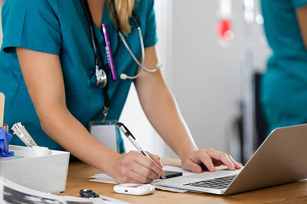 istock Healthcare professional using a laptop and writing notes in a clinic 2252438682