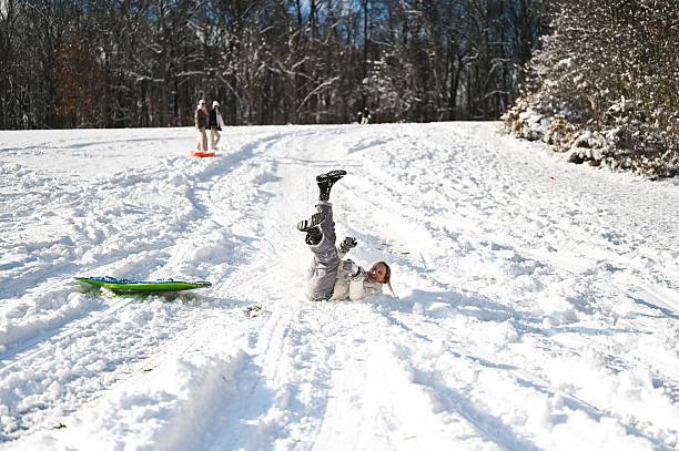 Woman falling down on the snow road.