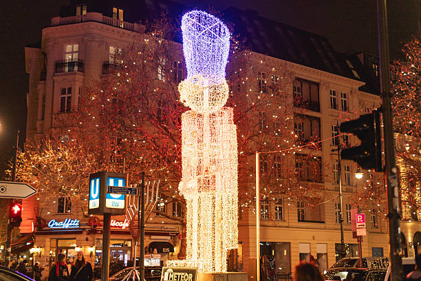 Berlin, Germany – December 13, 2025: Tall illuminated nutcracker Christmas figure installed near a subway entrance, surrounded by festive lights and city buildings at night.