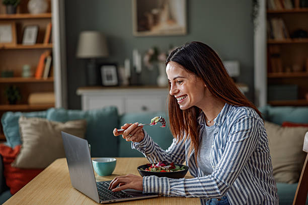 istock Smiling Woman Working From Home While Eating Healthy Lunch 2252442025