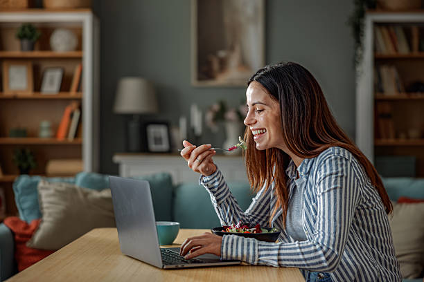 istock Smiling Woman Working From Home While Eating Healthy Lunch 2252442050
