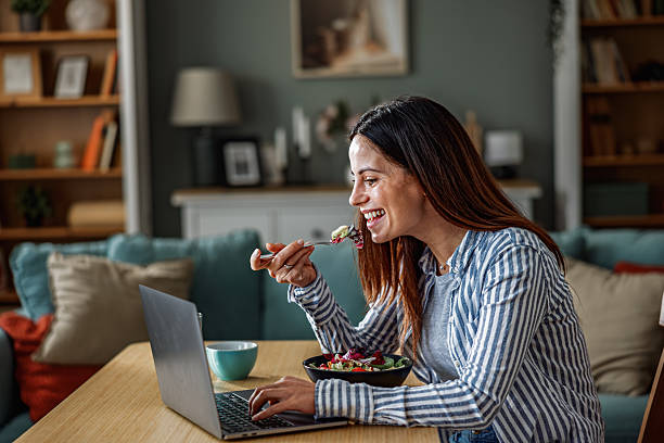 istock Smiling Woman Working From Home While Eating Healthy Lunch 2252442054