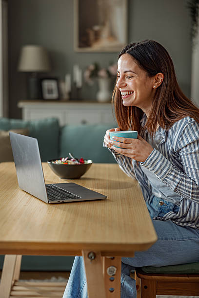 istock Smiling Woman Working From Home While Eating Healthy Lunch 2252442090
