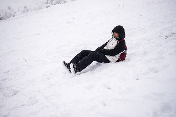istock Young man sledding down snowy hill enjoying winter fun 2252443664