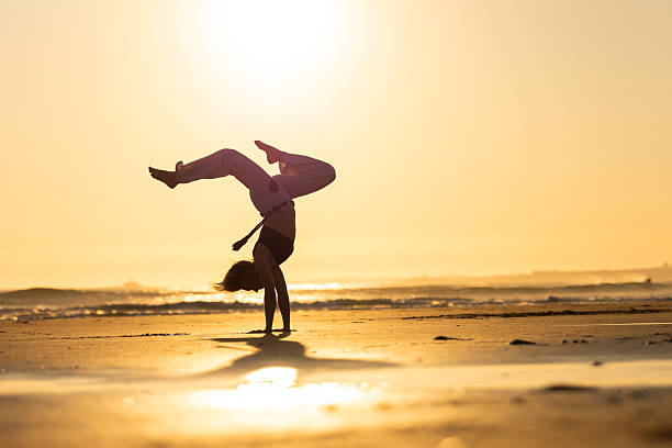 istock Capoeirista performing handstand on beach during sunset 2252444050