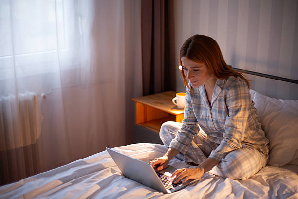 istock Woman working on laptop in bed during morning 2252444536