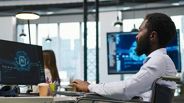istock IT professional in wheelchair in inclusive office developing software with AI 2252445580