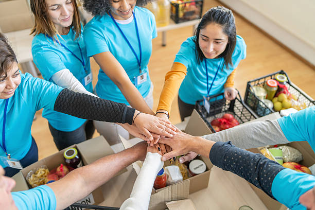 istock Volunteers stacking hands during food drive donation event 2252449027