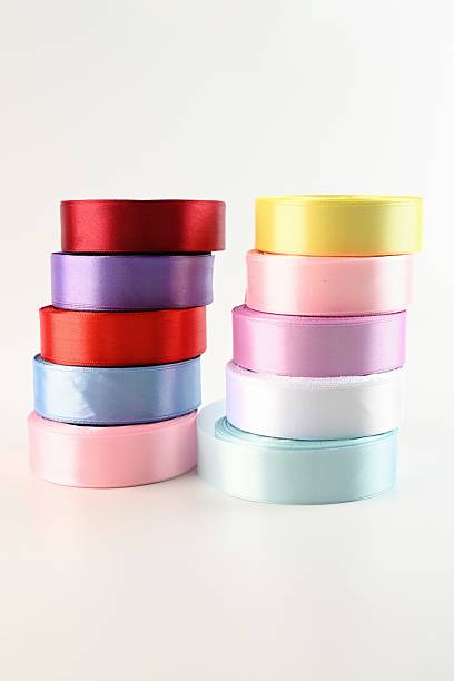 istock Colorful satin ribbon rolls stacked on a white background, showcasing smooth texture and vibrant shades used for floral wrapping and decorative crafts. 2252452948
