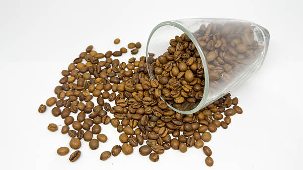 istock Roasted Coffee Beans Spilled from a Glass on White Background 2252476175