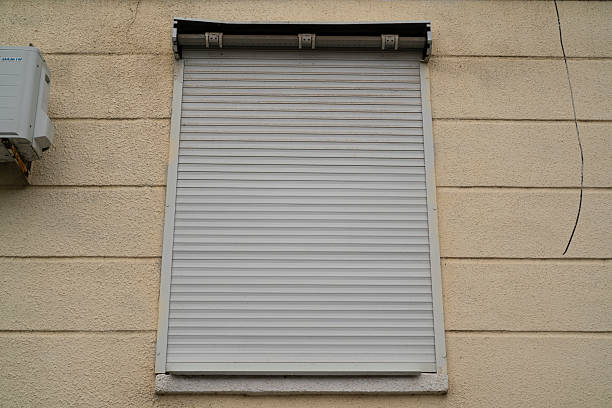 istock A closed roller shutter covers a window on a yellow wall in a city setting during the day 2252479353