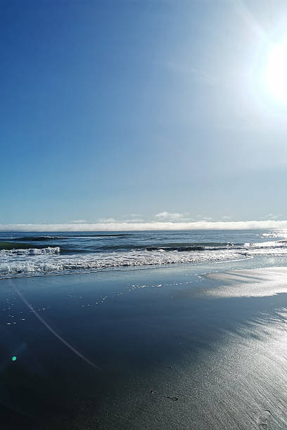 istock Waves crash gently on sandy shore under morning sun 2252482764