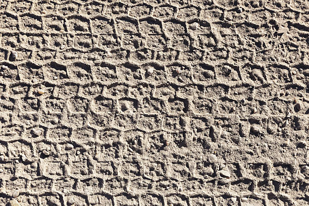 Agricultural tractor tire tread mark in fine dust of an countryside dirt road as texture and background, top view