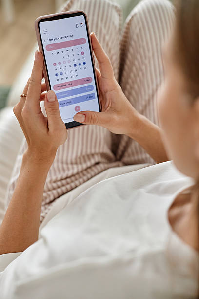 istock Young Woman Using Smartphone Tracking Menstrual Cycle Calendar 2252484754