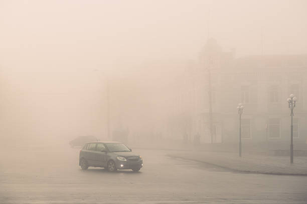 istock Car driving through dense urban fog 2252489313