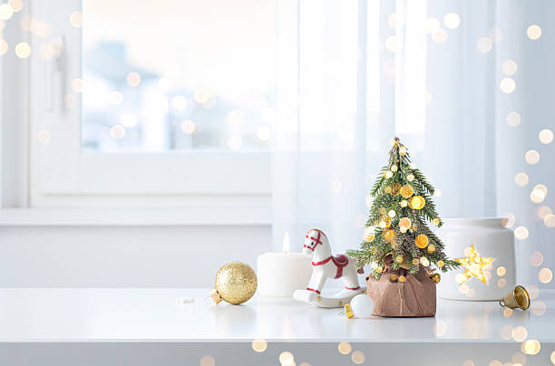 istock Shiny white Christmas table space with decorative fir tree, horse figurine and other objects on pastel window festive interior background 2252491097