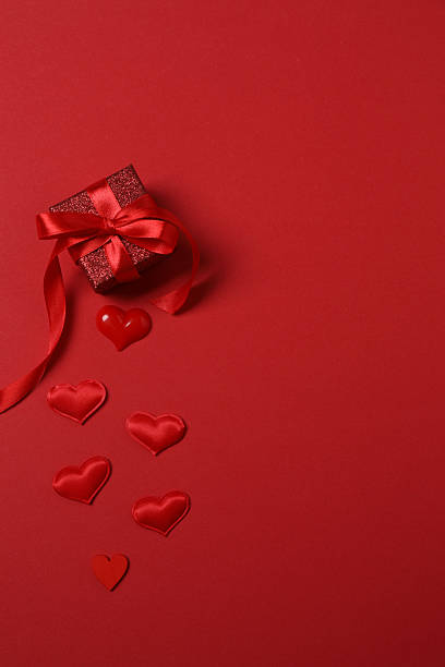 istock Valentine's Day banner with gift boxes wrapped in red ribbons, surrounded by red hearts on a red background. Ideal for romantic and festive events 2252492020