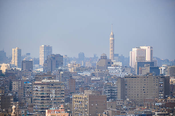 View of Cairo dense urban skyline combining modern high-rise buildings with historic mosque minarets rising above the city