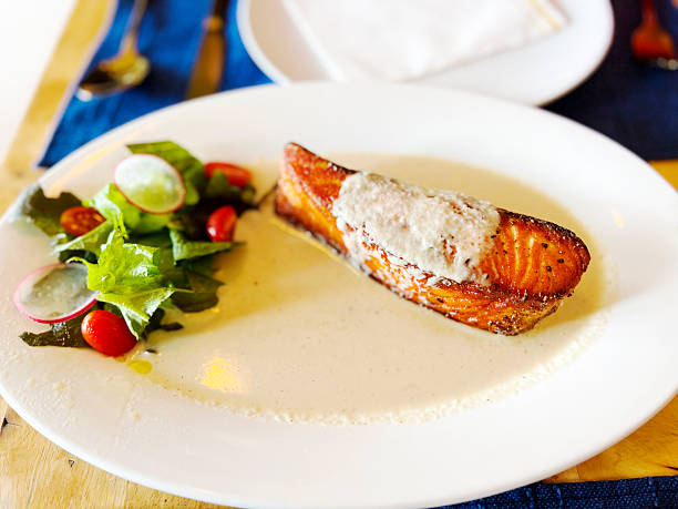 Fresh raw salmon fish fillet with cooking ingredients, herbs and lemon. Copy space.