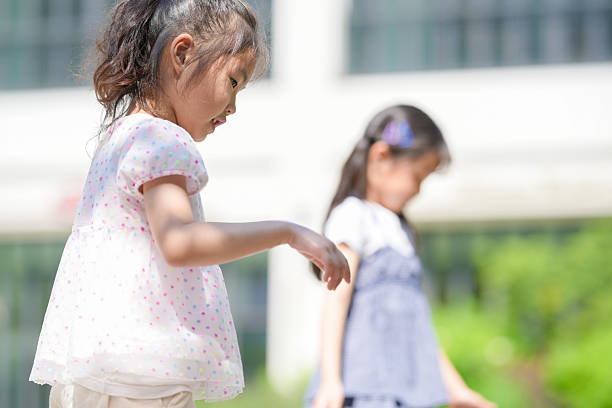 Smiling Asian little boy and girl child with hand in hand while playing together in the garden.