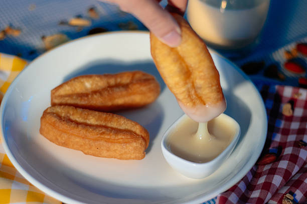 istock Hand dipping a deep-fried dough stick (Pa Tong Go) into sweetened condensed milk 2252495902