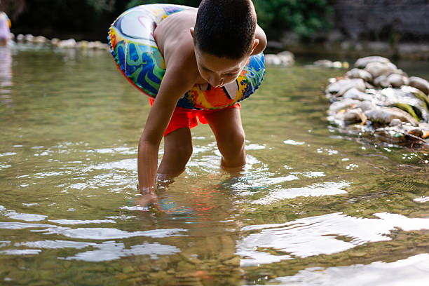 istock Young boy playing in river with swim ring 2252496712