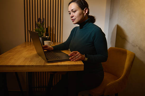 istock Telecommuting Woman Working On Laptop In Cozy Modern Cafe Setting, Luxurious Interior 2252498958