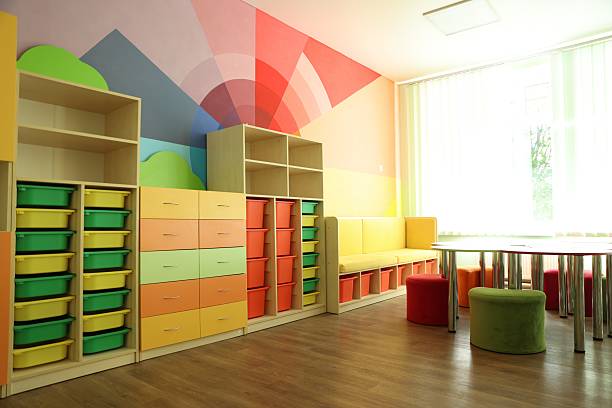 istock Desks, chairs and shelving unit near bright wall in classroom 2252503675
