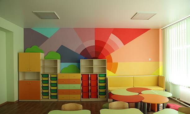 istock Desks, chairs and shelving unit near bright wall in classroom 2252503701