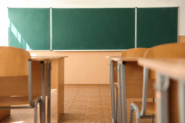 istock Desks with chairs and green chalkboard in classroom 2252503819