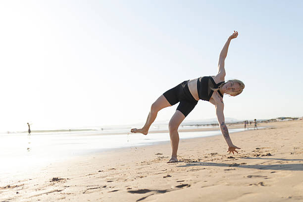 istock Woman balancing in half moon pose on sunny beach 2252504090