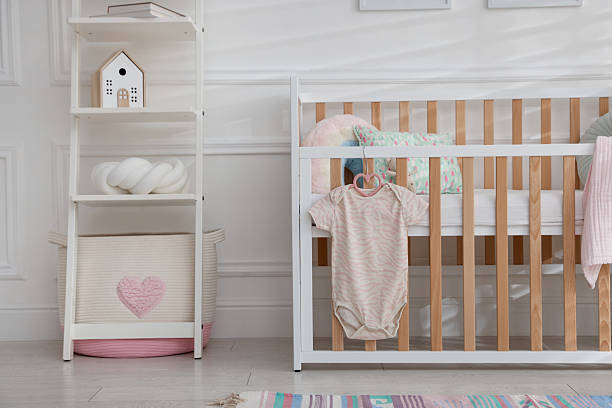 istock Crib with onesie and shelving unit in baby's room 2252505310