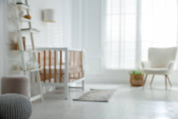 Blurred view of baby's room with stylish crib