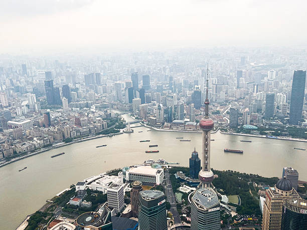 Aerial view of Shanghai city skyline showing Pudong and Puxi, overview of Huangpu river, the Bund and Lujiazui after dusk, China
