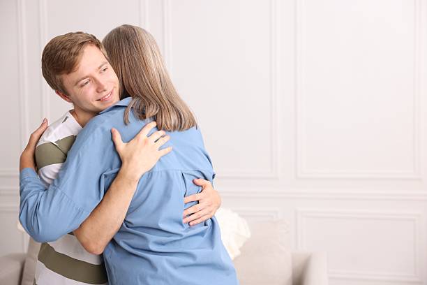 istock Smiling son hugging his mother at home. Space for text 2252507786