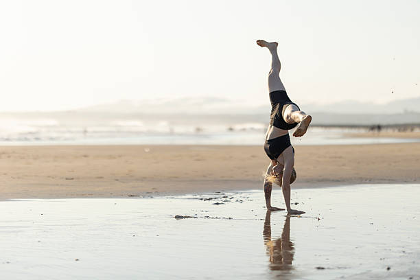 istock Woman performing handstand on beach enjoying active freedom 2252508086