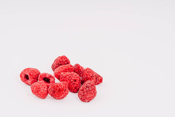 istock Freeze-dried raspberries scattered on a clean white surface, showcasing their vibrant red color and unique texture, perfect for healthy snacks, baking, or adding to smoothies and desserts with copy space 2252509893