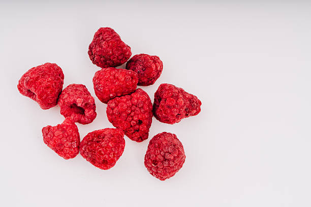istock Freeze-dried raspberries scattered on a clean white surface, showcasing their vibrant red color and unique texture, perfect for healthy snacks or culinary creations with copy space 2252510503