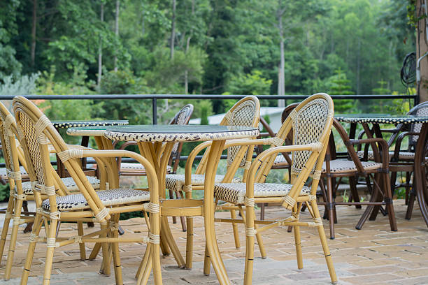 istock Empty outdoor restaurant dining area with rattan chairs surrounded by greenery 2252510707